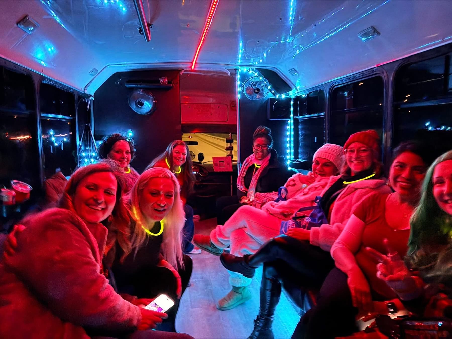 A group lit red and blue by the 16's LED lights, celebrating on board
