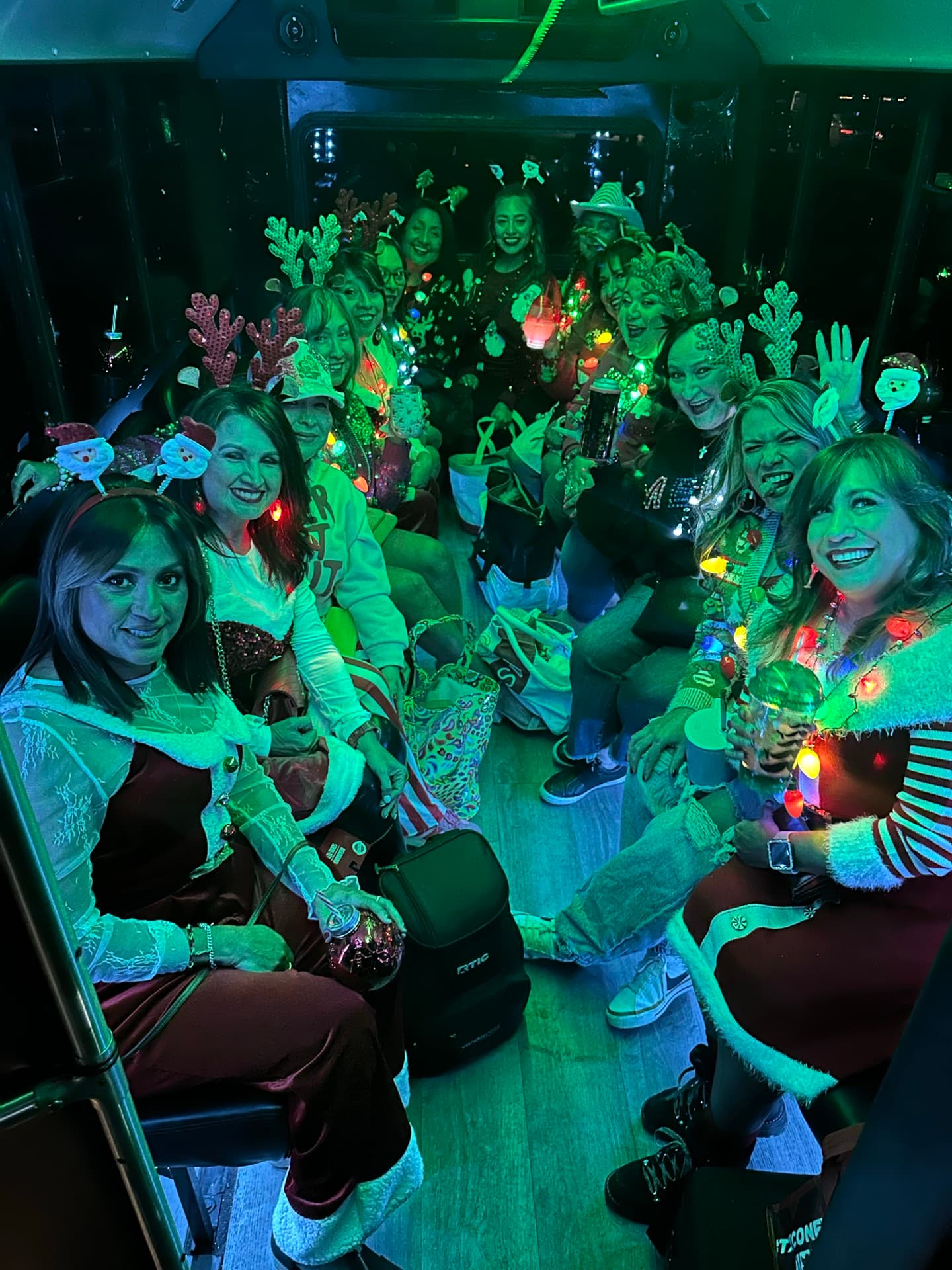 A group under green party lights raising their hands