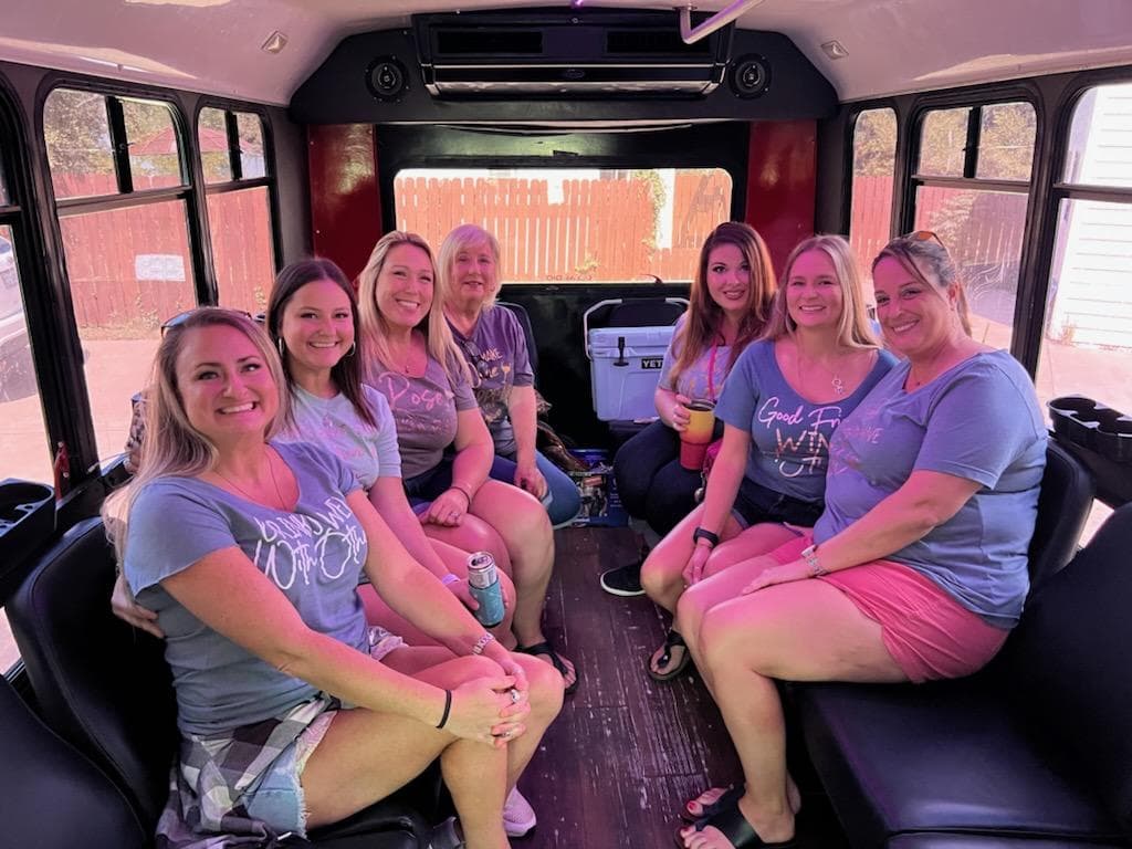 Friends in matching wine-tour shirts on the 16, with a cooler in the aisle