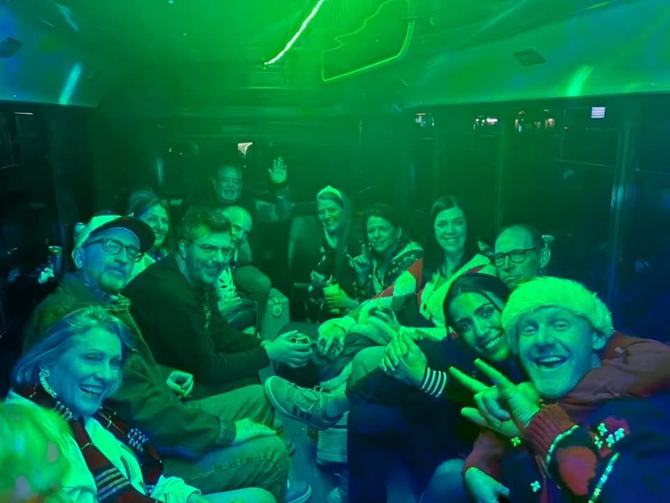 A group under green LED lights along the side seating